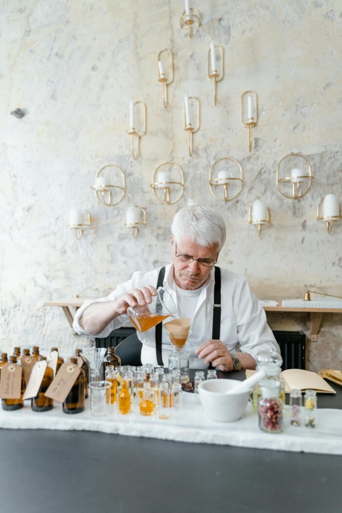 An experienced perfumist mixing natural ingredients for fragrance creation.